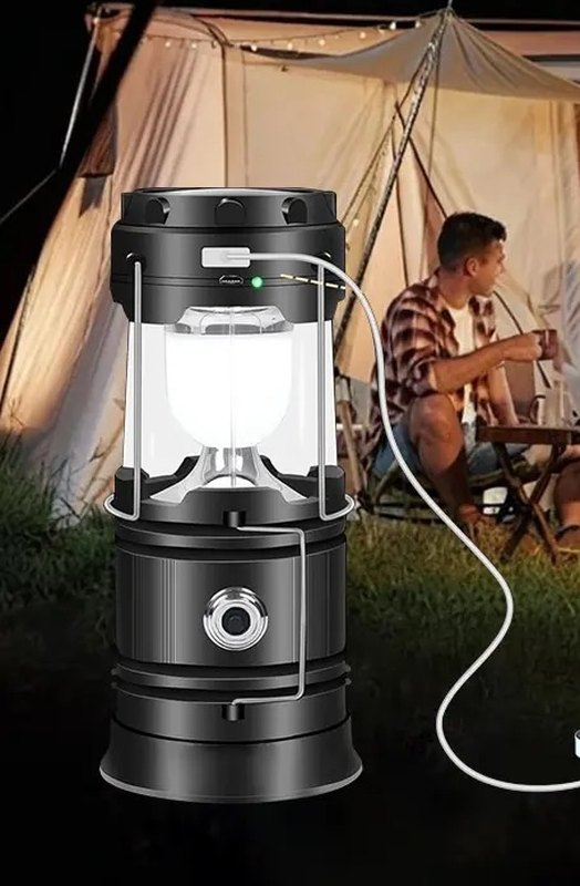The lantern with a USB cable plugged into its output port at a campsite