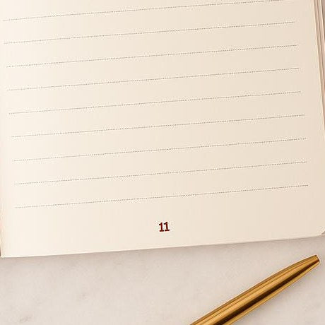 A cream lined answer page of the Pomence journal with a gold pen