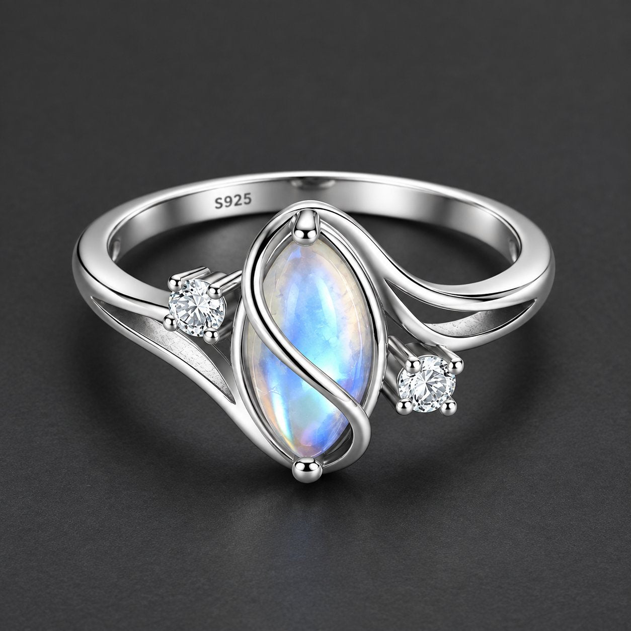 The Pomence Moonstone Ring alone on a dark neutral ground, lit to show the blue flash in the stone