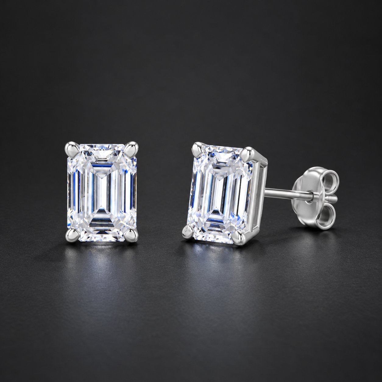 A pair of Pomence Moissanite Stud Earrings on a dark neutral surface, lit to show the faceted stones
