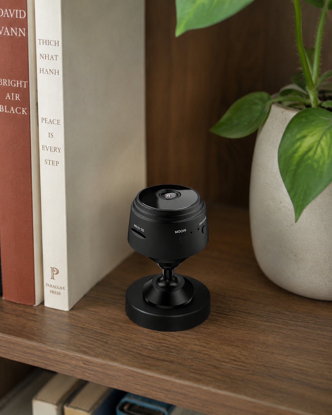 Pomence Mini WiFi Security Camera resting on a shelf among ordinary home decor