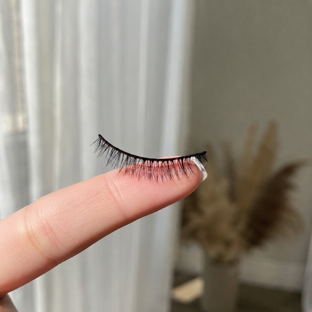 Magnetic lash resting weightlessly on a fingertip