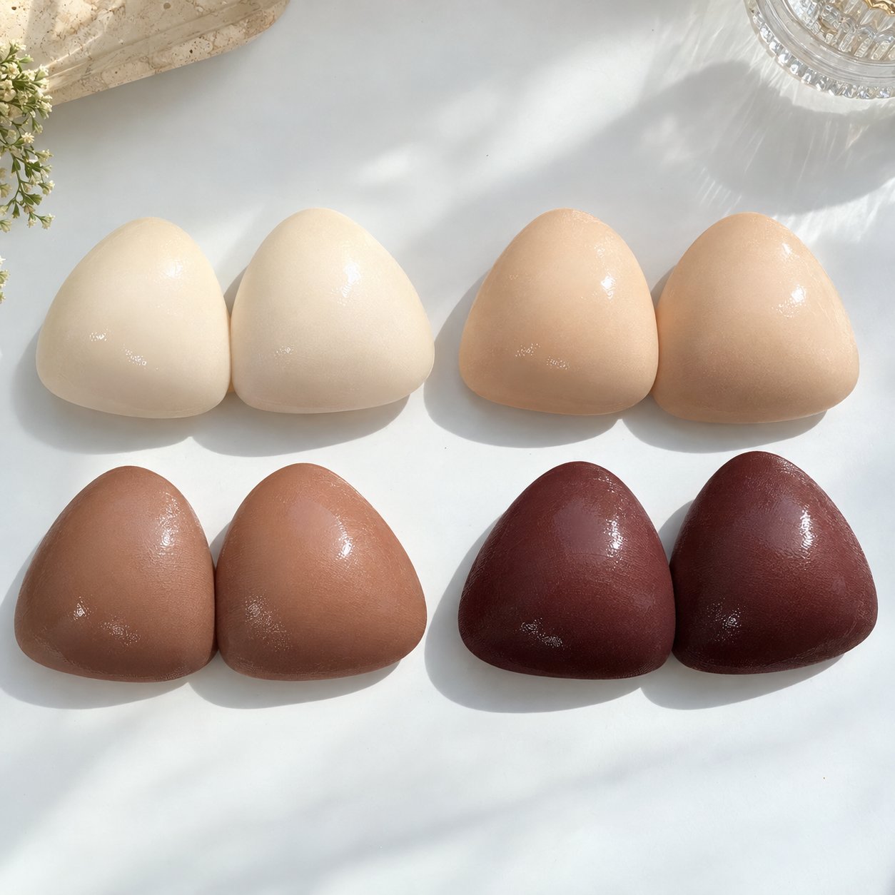 Four Pomence sticky bra insert shades laid out side by side