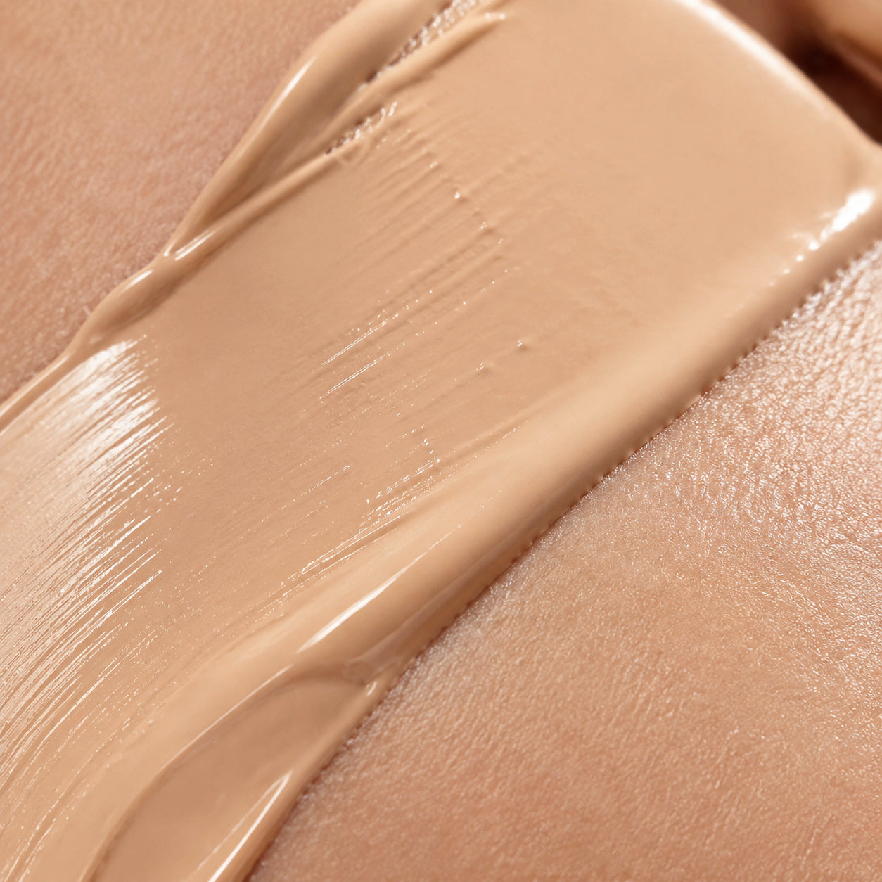 Macro close-up of foundation cream blending into skin