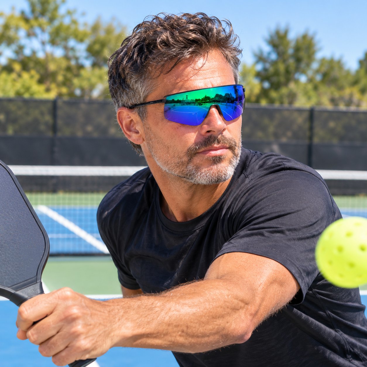 A player on a bright outdoor court wearing the Pomence™ Photochromic Sport Sunglasses in the Blue colorway