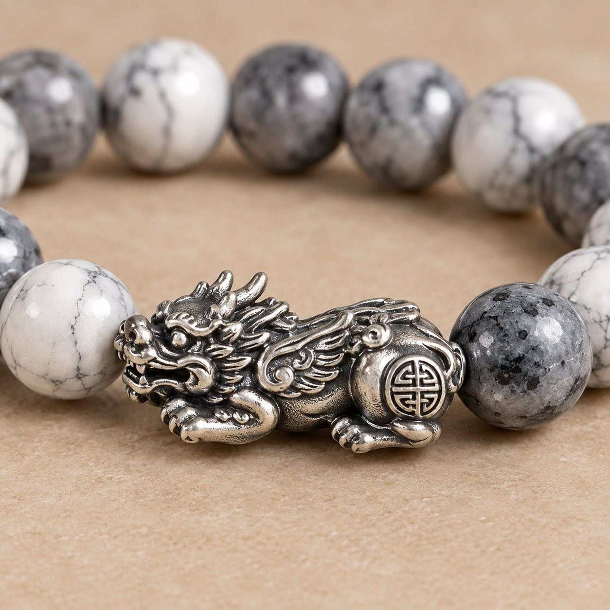 Close macro of the carved antique silver tone Pixiu charm on the Pomence Pixiu Wealth Bracelet