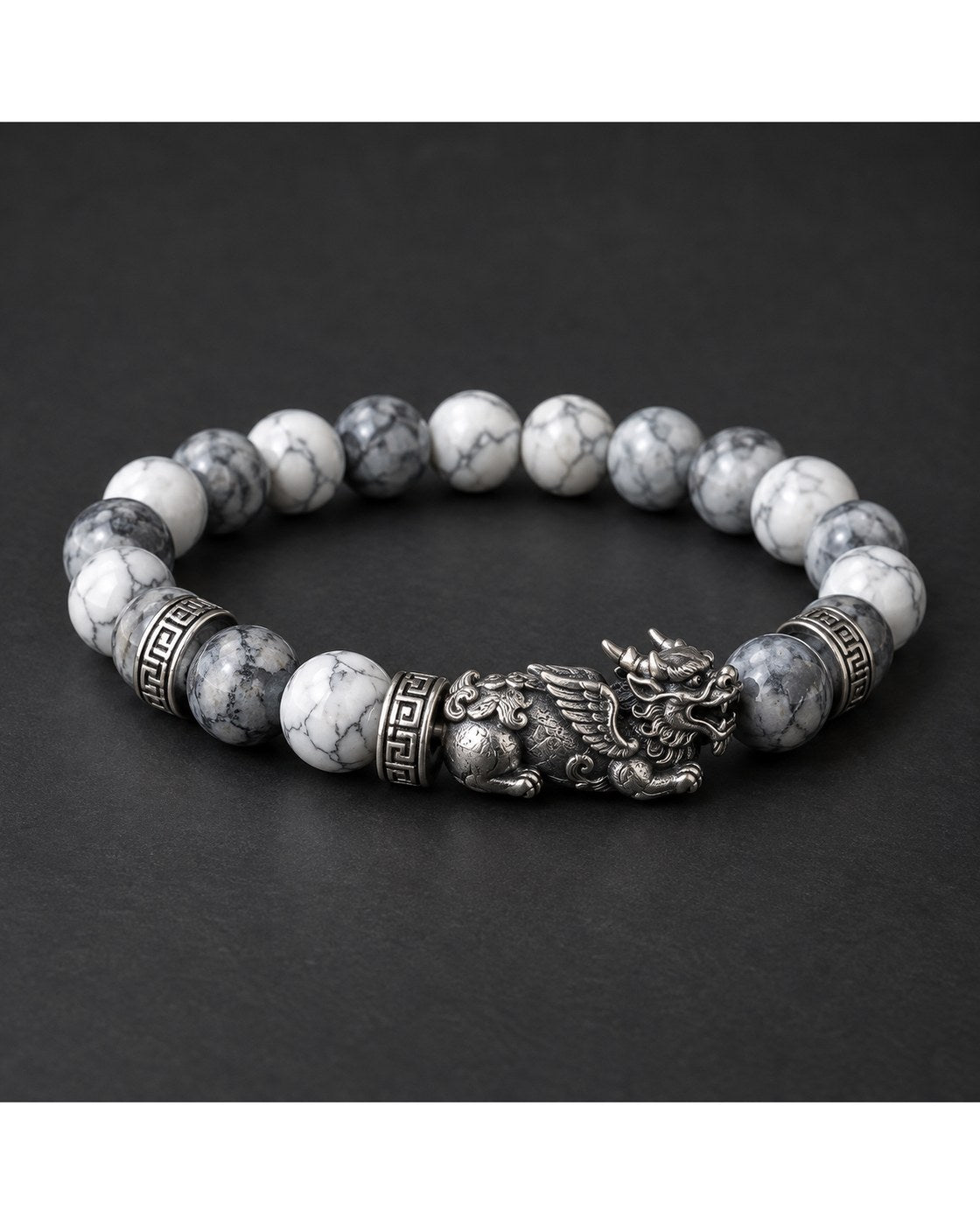 The Pomence Pixiu Wealth Bracelet coiled with the Pixiu charm at the top on a dark charcoal background