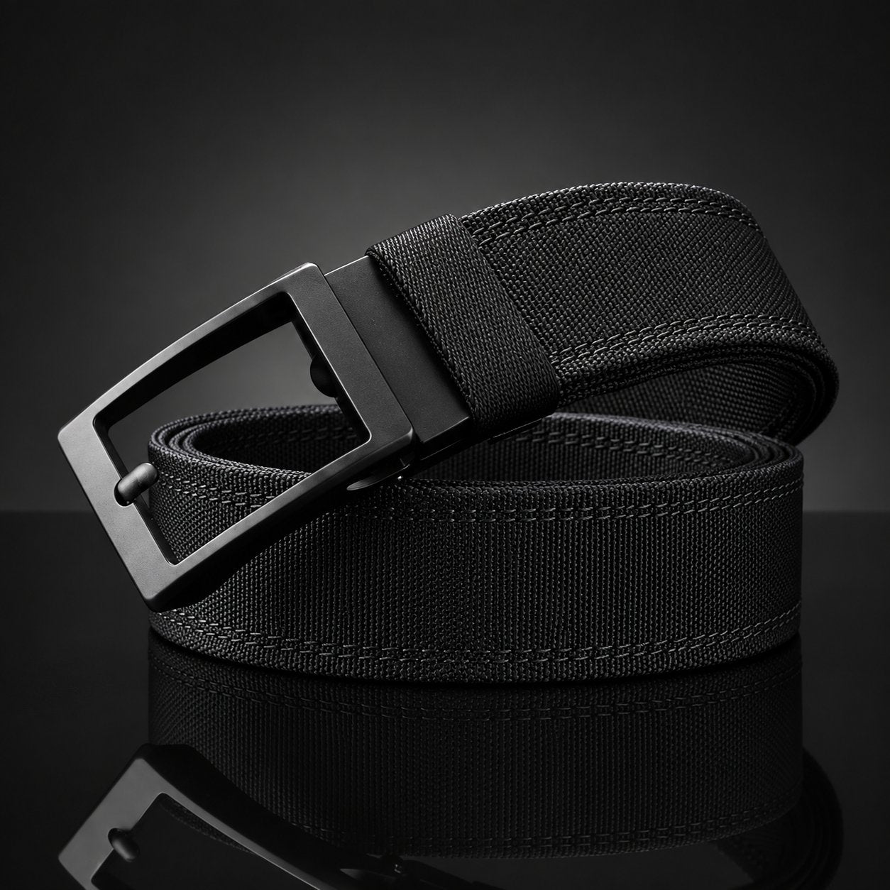 The Pomence Ratchet Tactical Belt in black, coiled on a dark ground