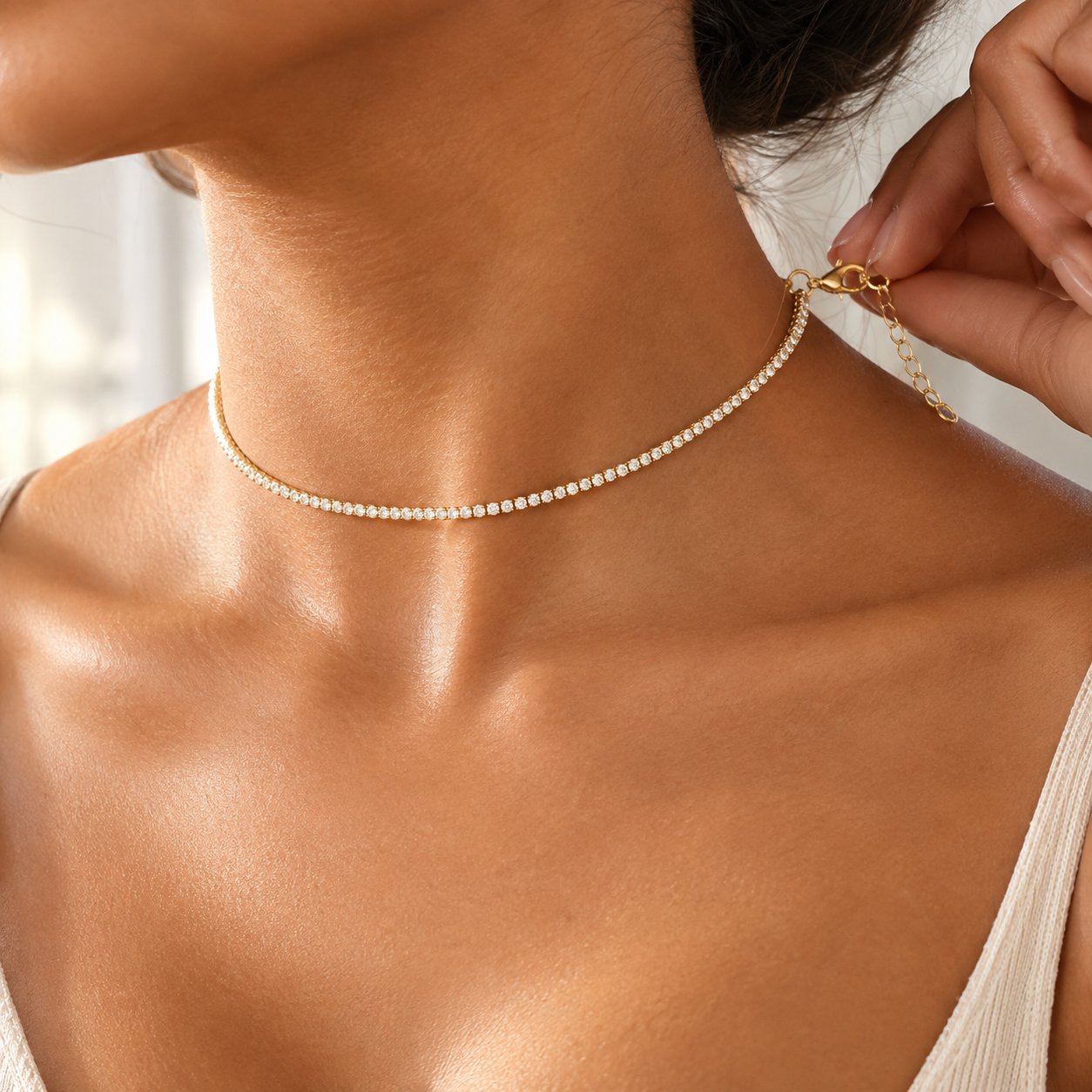 A hand reaching behind the neck to fasten the lobster clasp of the Pomence Tennis Necklace